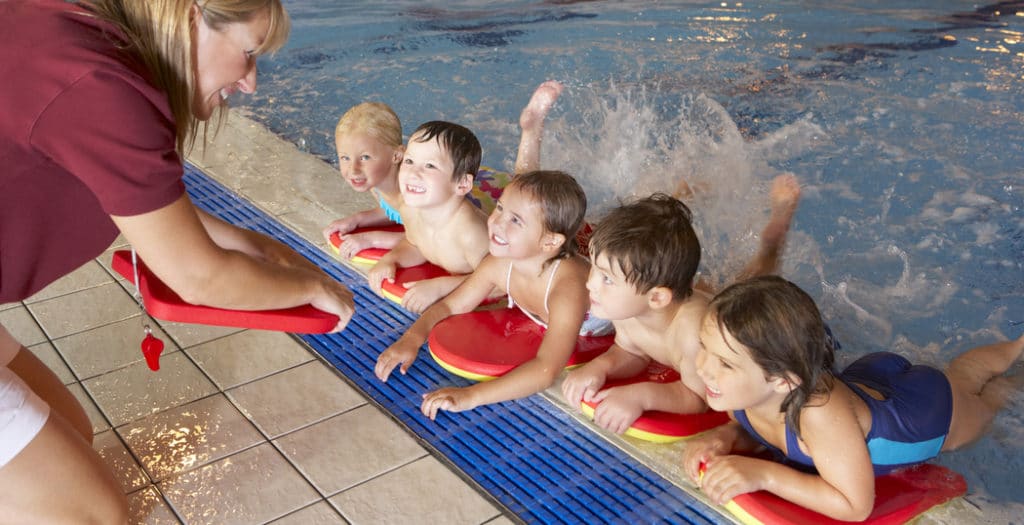 Children getting swimming lessons at community pool