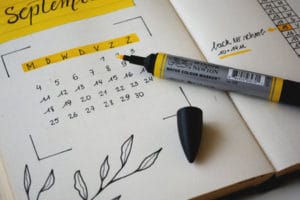 Date book with yellow highlighter open to a month