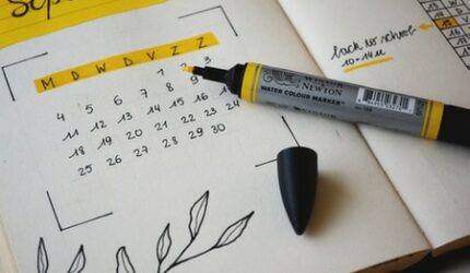 Date book with yellow highlighter open to a month