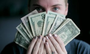 Money fanned in front of woman's eyes