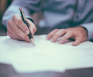 close up of man signing documents