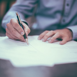 close up of man signing documents