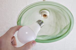Close-up of energy-saving LED light bulb in human hand.