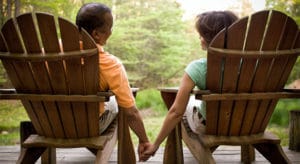 Older generation couple holding hands sitting in lawn chair