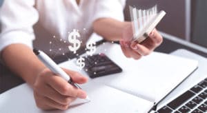 Money planning lady using calculator and making notes