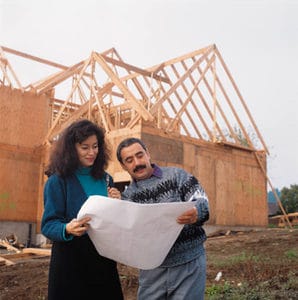 Buyer and builder looking at plans for new home