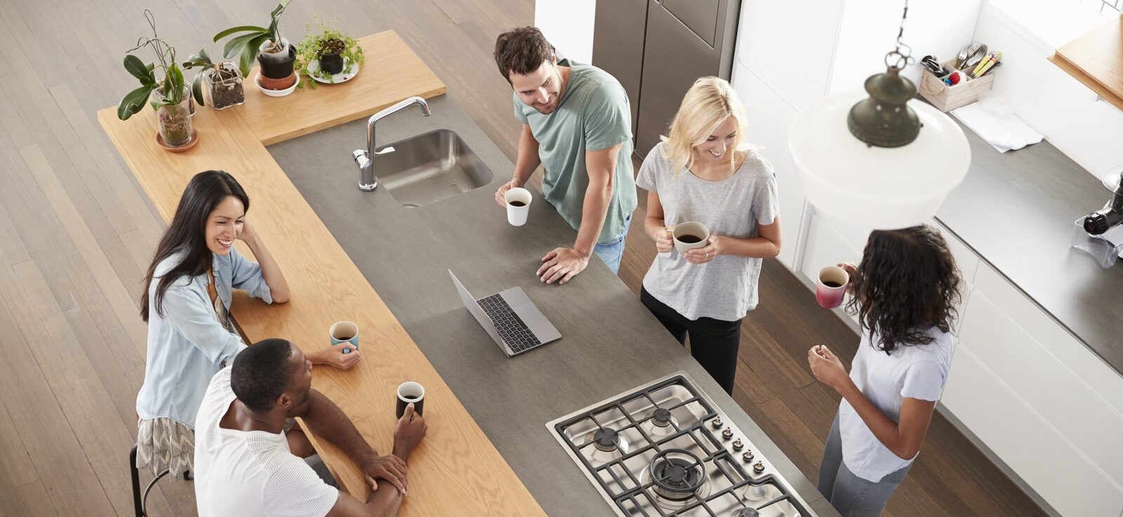friends and family gathered around a kitchen enjoying coffee