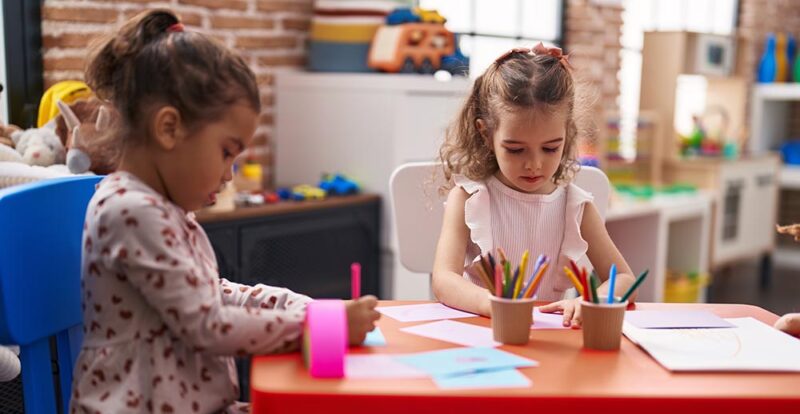 Six simple staging tips for a messy kids room when you're selling - two little girls coloring at table 