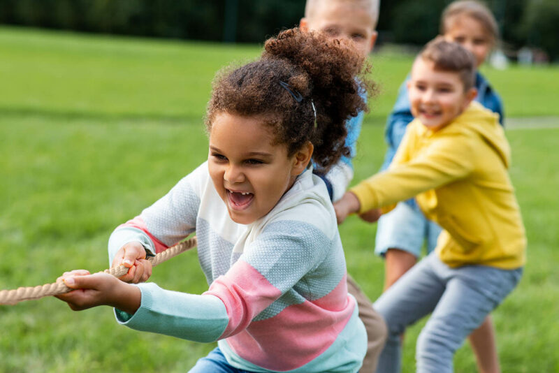 Kids playing tug of war at park in Princeton