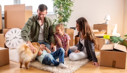 Family in the process of moving boxes with children and dog