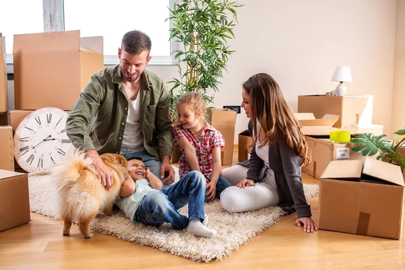 Family in the process of moving boxes with children and dog