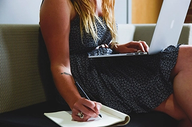 Communication lady making notes and working on laptop