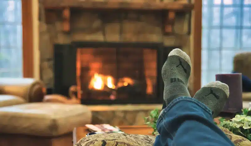 Winter-ready Cozy fireplace, sock feet from man laying on sofa